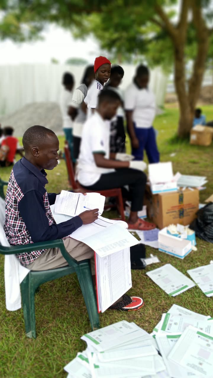 Health worker reviewing records during a community outreach session